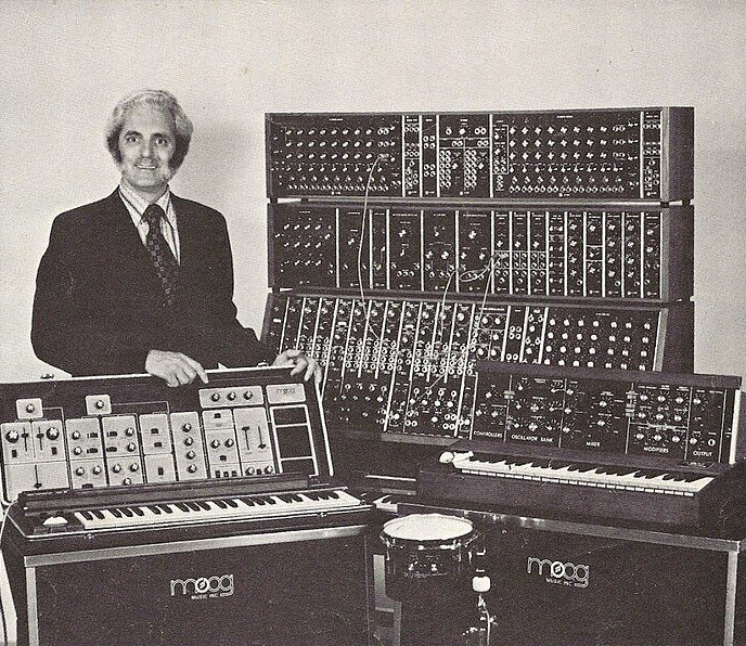 Robert Moog posant avec quelques synthétiseurs de son invention